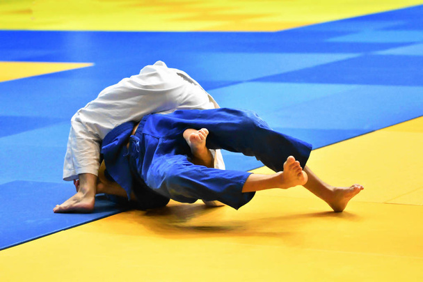 Two Boys judoka in kimono compete on the tatami - Photo, Image
