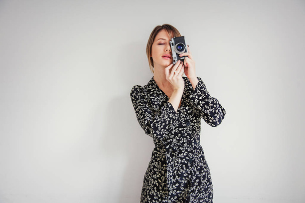 Beautiful woman in trendy dress with vintage camera - Photo, Image