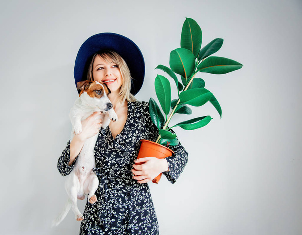 Žena v moderní šaty s rostlinou v hrnci a pes - Fotografie, Obrázek