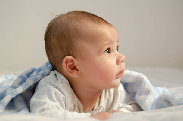 Ładna 4 miesiące chłopca o czas brzuch na biały kołdra pokryta niebieski koc - zdrowie i szczęśliwe dzieciństwo koncepcja - Zdjęcie, obraz