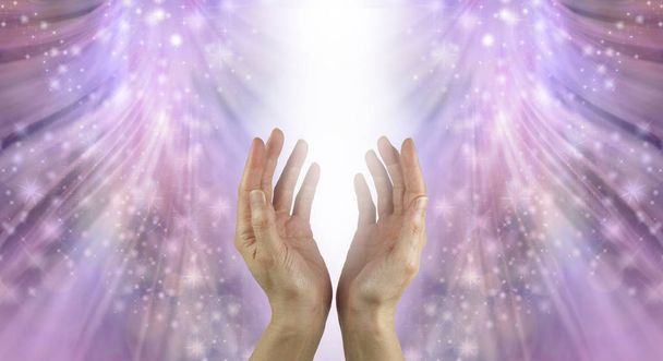 Pływanie ręce w pięknym Healing rezonansu-kobiece cupped ręce sięgając do strumienia białego światła z połyskujące błyszczy spływające na promieniujący różowy Eterowy tło formacji energii z przestrzeni kopiowania - Zdjęcie, obraz