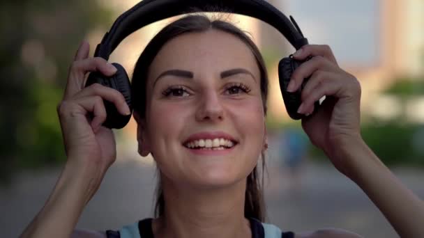 girl puts on headphones includes and listens to music on the phone and dancing. close-up. 4k - Footage, Video