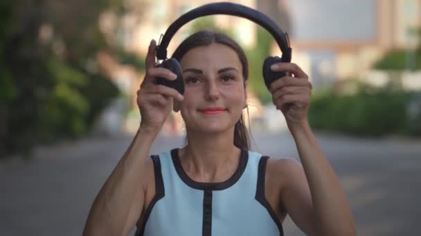 menina coloca fones de ouvido inclui e ouve música no telefone e dança. close-up. 4k
 - Filmagem, Vídeo