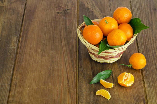 Bos van vers mandarijnen, clementines en mandarijnen in mand en bladeren close-up. Studio foto - Foto, afbeelding