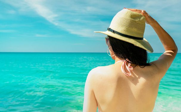 Назад подання сексуальні молоді азіатські жінки носити рожеві бікіні, солом'яний капелюшок і сонцезахисні окуляри, розслаблюючий і насолоджуйтеся відпочинком в тропічний рай beach. Дівчата мода літо відпочинок. Краса сексуа. Літній vibes. - Фото, зображення