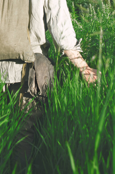 soldado está en el campo tocando la mano de la hierba alta
 - Foto, Imagen