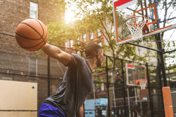 Afro-american basketball player training on a court in New York - Sportive man playing basket outdoors - Photo, image