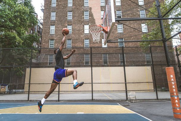 Afro-american basketball player training on a court in New York - Sportive man playing basket outdoors - Fotó, kép
