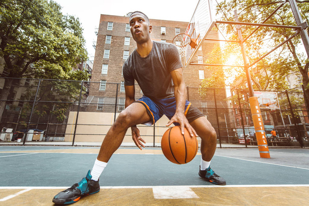 Afro-american basketball player training on a court in New York - Sportive man playing basket outdoors - 写真・画像