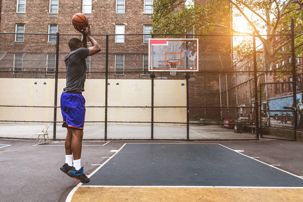 Afro-american basketball player training on a court in New York - Sportive man playing basket outdoors - Foto, Imagen