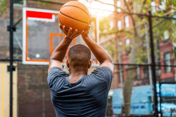 Afro-amerykański koszykarz, szkolenia na sąd w Nowym Jorku - sprawny człowiek w kosz na zewnątrz - Zdjęcie, obraz