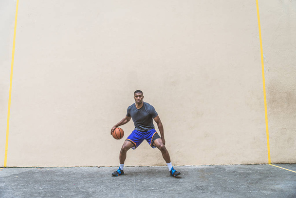 Afro-american basketball player training on a court in New York - Sportive man playing basket outdoors - Foto, afbeelding