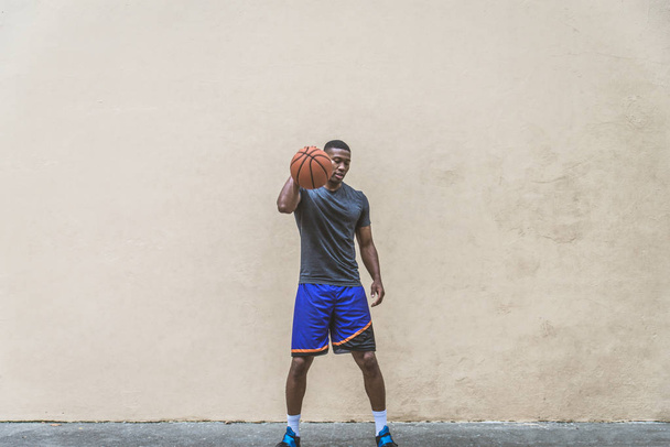 Afro-american basketball player training on a court in New York - Sportive man playing basket outdoors - Photo, image