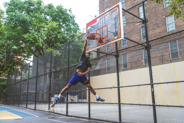Afro-american basketball player training on a court in New York - Sportive man playing basket outdoors - Фото, зображення