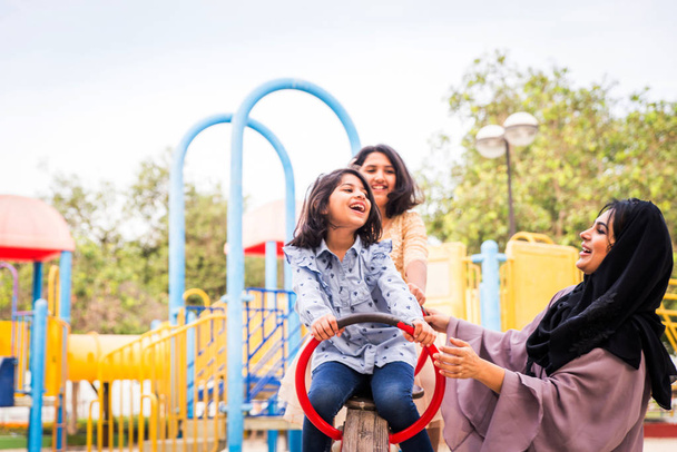 Happy arabian family having fun in Dubai - Mom together with her daughters in park play area - Foto, afbeelding