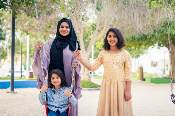 Happy arabian family having fun in Dubai - Mom together with her daughters in park play area - Photo, image