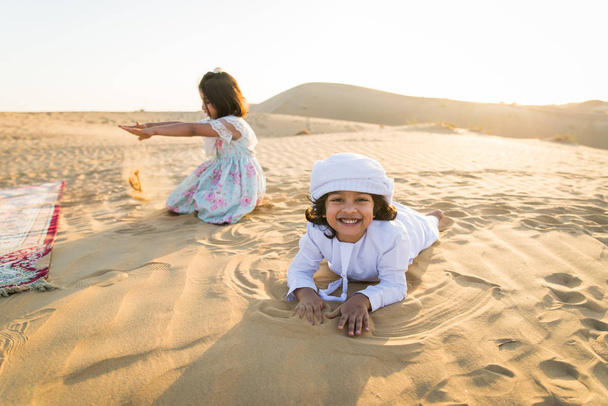 Arabian family with kids having fun in the desert - Parents and children celebrating holiday in the Dubai desrt - Foto, imagen