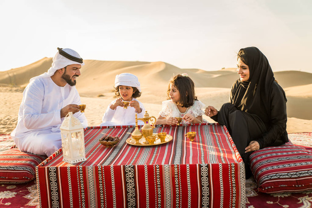 Arabian family with kids having fun in the desert - Parents and children celebrating holiday in the Dubai desrt - Photo, Image
