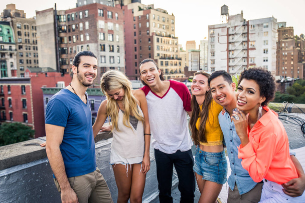Young happy people having a barbecue dinner on a rooftop in New York - Group of friends having party and having fun - Zdjęcie, obraz