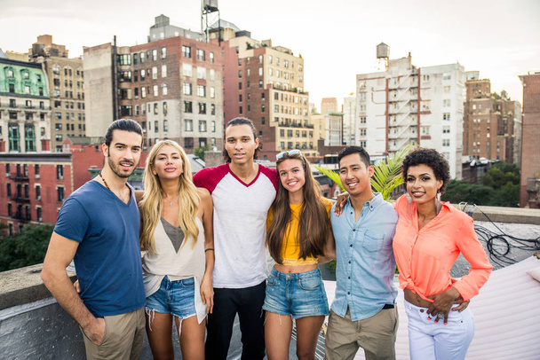 Young happy people having a barbecue dinner on a rooftop in New York - Group of friends having party and having fun - Fotó, kép