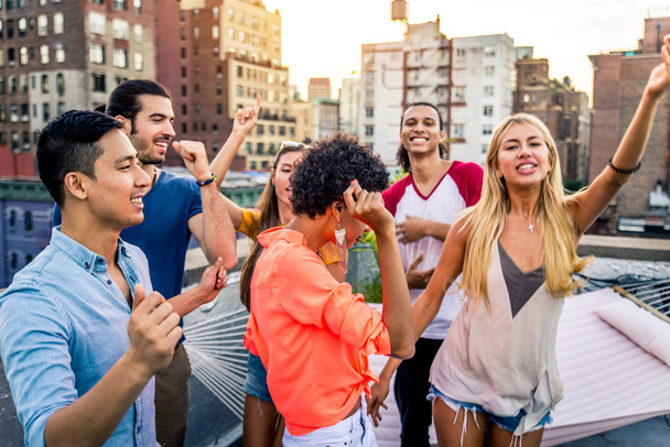 Молодий щасливі люди, що мають вечерю з барбекю на даху в Нью-Йорку - групою друзів, маючи партії і весело - Фото, зображення