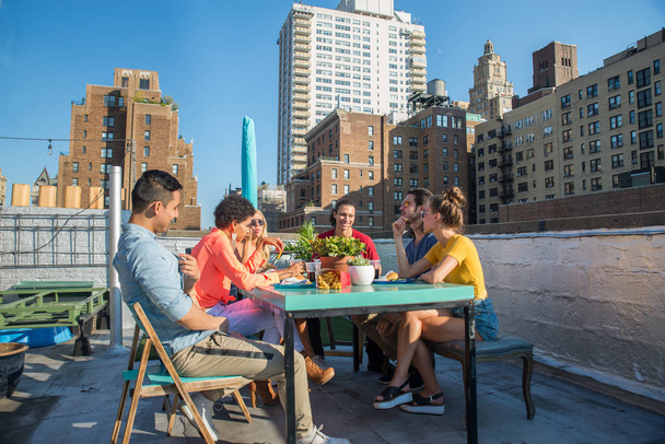 Young happy people having a barbecue dinner on a rooftop in New York - Group of friends having party and having fun - Fotografie, Obrázek