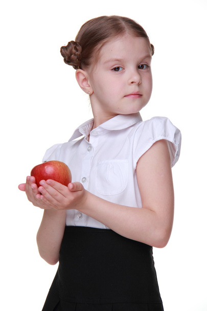 Portrait of a beautiful schoolgirl holding an apple - Foto, imagen