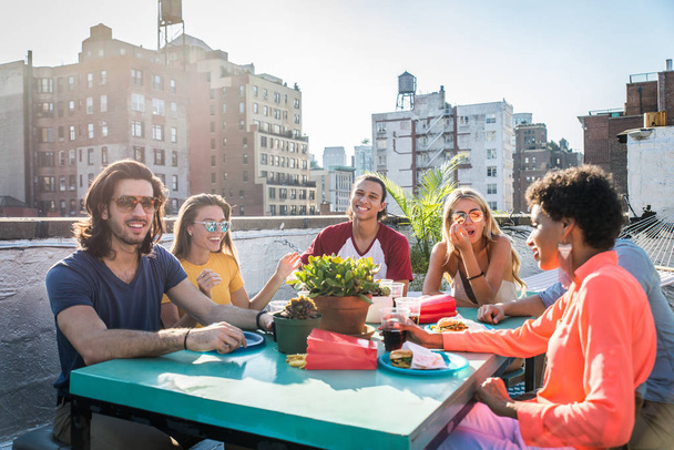 Young happy people having a barbecue dinner on a rooftop in New York - Group of friends having party and having fun - Foto, immagini