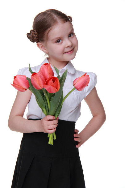 Cute schoolgirl with a bouquet of tulips - Фото, изображение