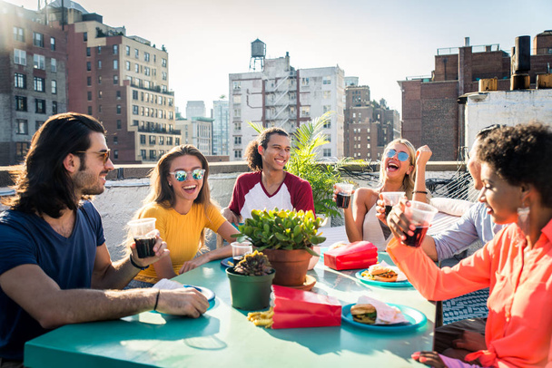 Молодые счастливые люди, ужинающие барбекю на крыше в Нью-Йорке - Группа друзей, весело проводящих время
 - Фото, изображение
