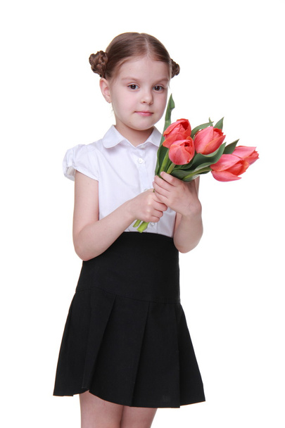 Cute schoolgirl with a bouquet of tulips - Foto, Imagen