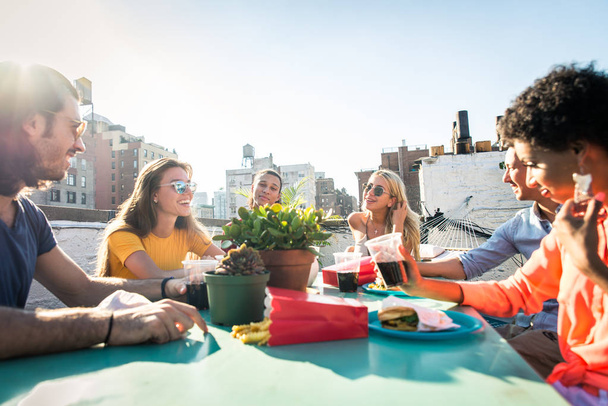 Young happy people having a barbecue dinner on a rooftop in New York - Group of friends having party and having fun - Foto, afbeelding
