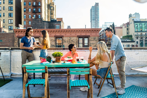 Young happy people having a barbecue dinner on a rooftop in New York - Group of friends having party and having fun - Photo, Image