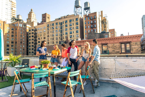 Young happy people having a barbecue dinner on a rooftop in New York - Group of friends having party and having fun - Valokuva, kuva