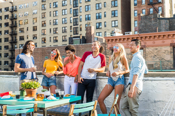 Young happy people having a barbecue dinner on a rooftop in New York - Group of friends having party and having fun - Photo, image