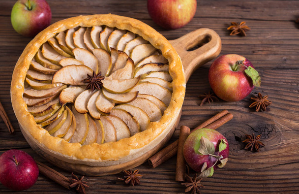 tasty homemade apple pie with cinnamon on wooden background - Foto, imagen