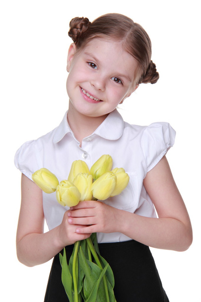 Cute schoolgirl with a bouquet of tulips - Фото, зображення