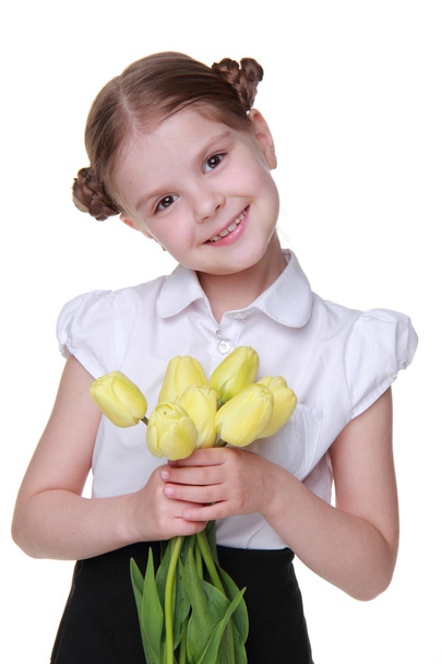 Cute schoolgirl with a bouquet of tulips - Фото, зображення