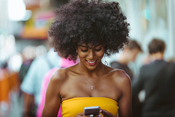 Happy african american woman smiling. Beautiful young female walking and having fun in New York city - Foto, imagen