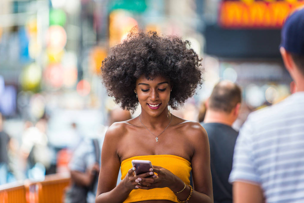 Happy african american woman smiling. Beautiful young female walking and having fun in New York city - 写真・画像