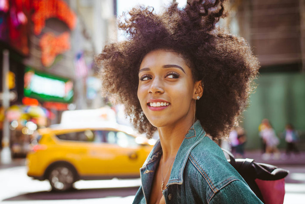 Happy african american woman smiling. Beautiful young female walking and having fun in New York city - Фото, изображение