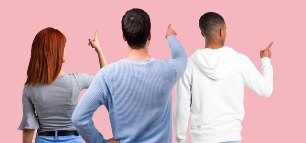 Group of three friends pointing back with the index finger - Фото, зображення