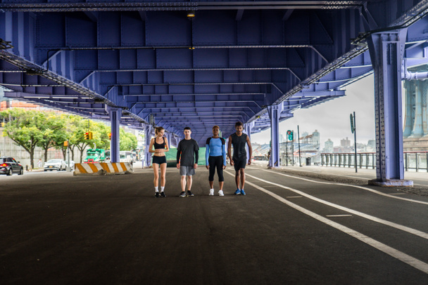 Многонациональная группа бегунов тренируется на свежем воздухе - здоровые люди бегают по улицам Манхэттена, рассказывают о спорте и здоровом образе жизни
 - Фото, изображение