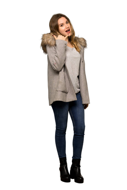 A full-length shot of a Teenager girl with coat making phone gesture. Call me back sign on isolated white background - Foto, immagini
