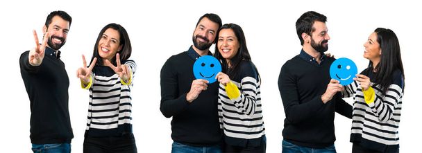 Colagem de casal segurando um ícone de rosto feliz
 - Foto, Imagem