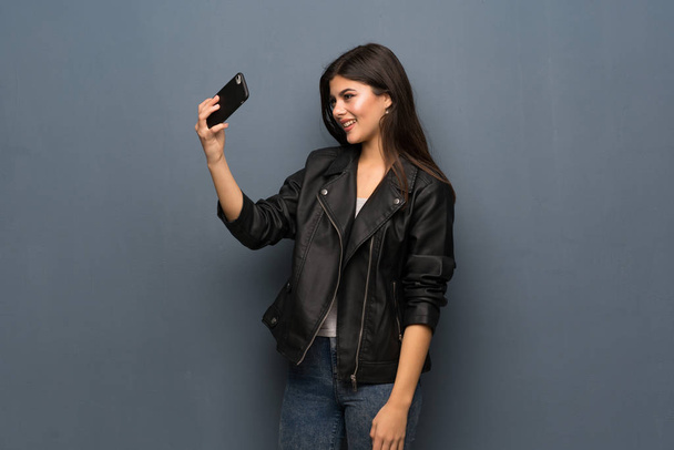 Teenager girl over grey wall making a selfie - Zdjęcie, obraz