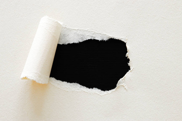 black background with hole in the white paper. Copy space - Photo, image