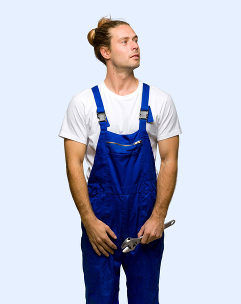 Workman looking up with serious face on isolated background - Foto, Bild