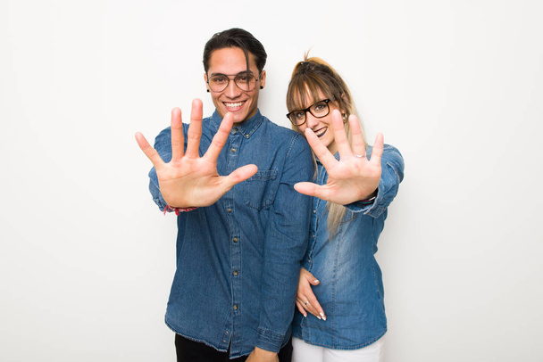 Young couple with glasses counting five with fingers - Photo, Image