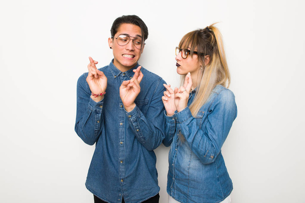 Νεαρό ζευγάρι με γυαλιά με τα δάχτυλα διασχίζοντας και εύχεται το καλύτερο - Φωτογραφία, εικόνα